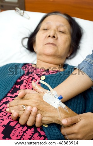 holding hands as for mental support to the sick people. grandma hand being hold by her daughter
