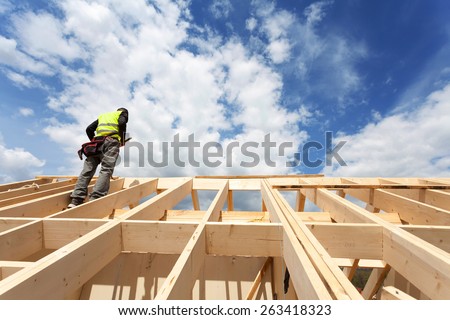 Construction crew working on the roof against blue sky