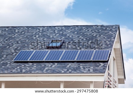 Solar water panel heating on new house roof with skylights against blue sky