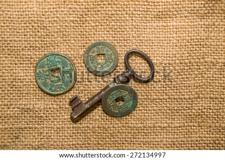 Antique bronze coins and keys on old cloth