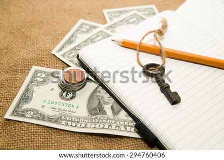 Opened notebook with a blank sheet, pencil, key and money on the old tissue