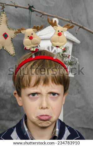 Cute sad boy in a Christmas Elf costume