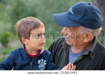 Child (grandson) tells a story his grandfather farmer