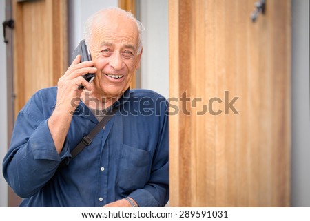 Retired farmer is talking on the phone and smiles on receipt of good news