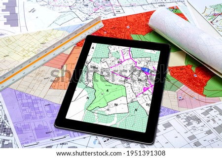 Town Planning and Land Use - digital tablet displaying a land use plan, placed on French maps of local town planning 