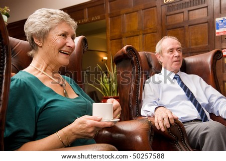Group of happy older senior friends enjoying each others company in an expensive hotel