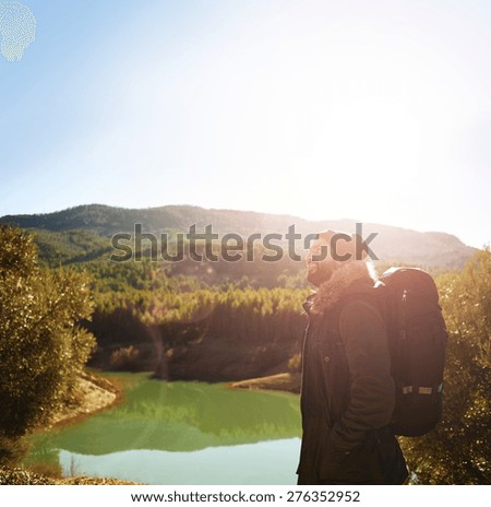 Hiking people - man hiker looking at landscape nature with mountains and lake in background. Happy multiracial strong man with backpack trekking outdoors.