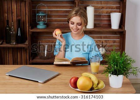 Lovely young woman working on laptop computer at home, attractive blonde hair student using laptop in her living room, female freelancer working at home