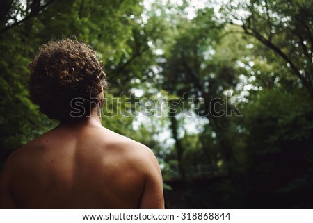 Close-up portrait of of the back of young man on forest background with copy space