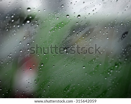 Drops of rain on car\'s mirror upon traffic jam.