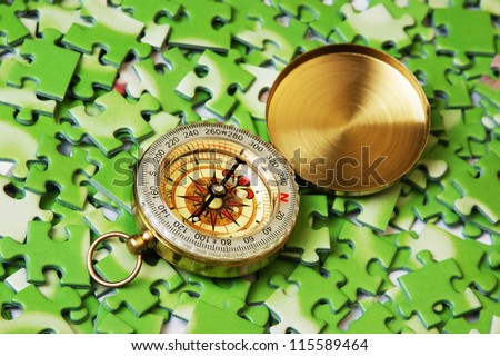 compass on pile of green puzzle