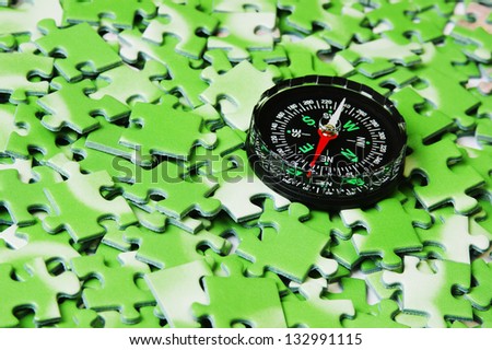 compass on pile of green puzzle