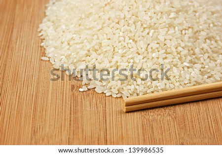 raw rice and chopsticks on bamboo board
