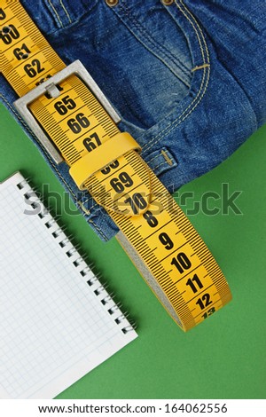 jeans with meter belt slimming and notebook on the green background