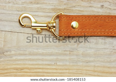 leather strap with carabiner on a wooden board
