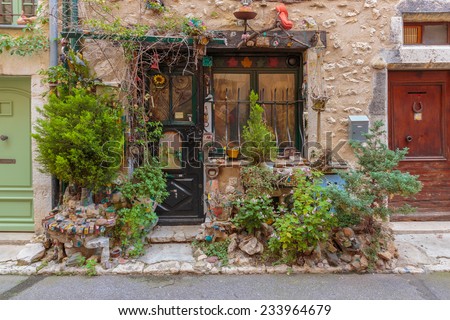 Entrance of the old village house decorated with flowers and old things, Provence France