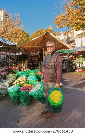 NICE, FRANCE - OCTOBER 30, 2014: Smiling seller florist in flower shop