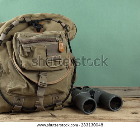 Old travel backpack and binoculars on the floor