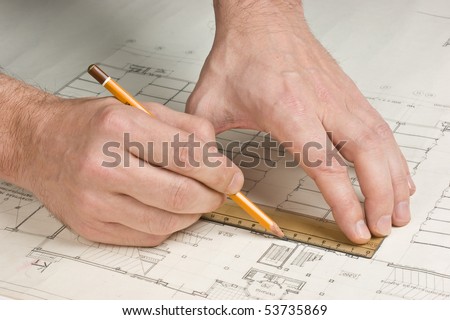 hand draws a pencil on the drawing
