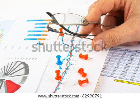 Glasses in hand and working paper