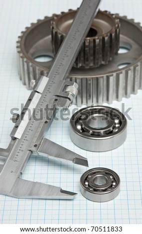caliper with gears and bearings on graph paper