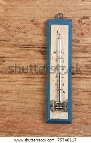 old thermometer on a wooden background