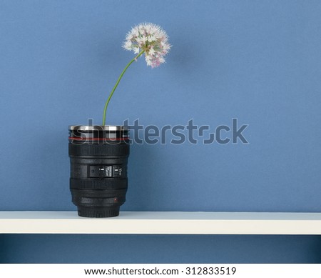 stylized vase-objective with flower on white  shelf on blue wallpaper background