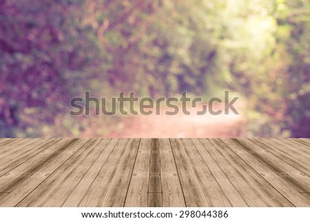 Vintage wooden board empty in autumn landscape.Perspective wood floor platform beside walk spring forest - can be used for display or montage your products. Beautiful sunlight. vintage filtered image.