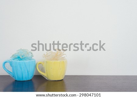 Two mug on wooden table over grunge background. Colorful stack coffee cups on wood board. Vintage retro effect style pictures.
