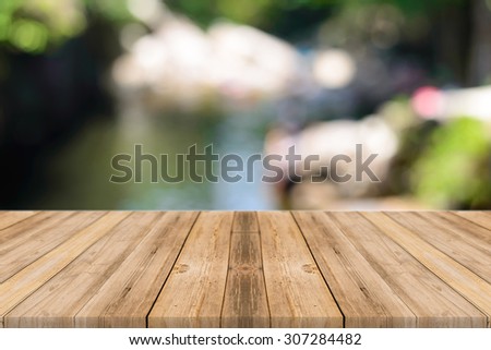Wooden board empty table in front of blurred background. Perspective brown wood over blur trees in forest - can be used for display or montage your products. spring season. vintage filtered image.
