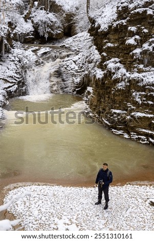 Similar – Foto Bild Männlicher Reisender auf Wasserfall in verschneiten bergigen Wald im Winter Tag