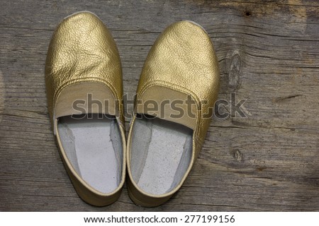gilded gymnastic slippers from skin on a floor