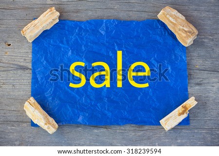 the announcement of the sale on a crumpled blue paper, fixed stones on the table from the old boards