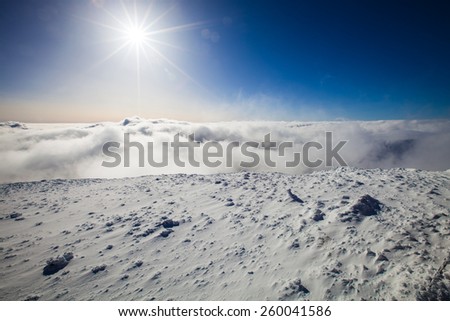 Alpine view of snow, sun and clouds