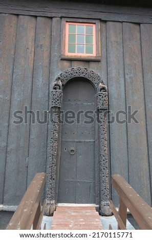 Carved wooden door portal of the Lom stave church in Lom Norway. Old black wooden wall and doorway, viking age animal style carving Stock fotó © 