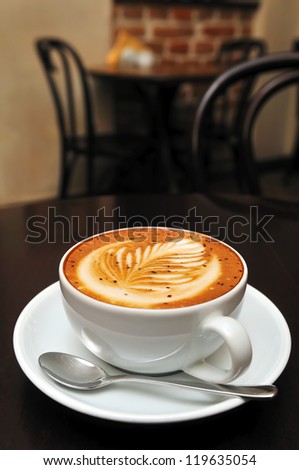 cappuccino cup on the dark brown table