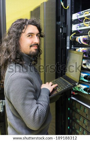 young engineer professional technician with modern laptop in computer server room