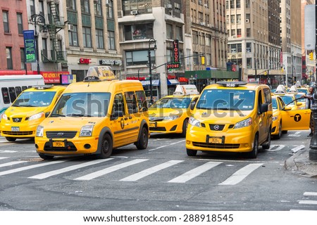 NEW YORK CITY - JUNE 14, 2015: Group of yellow taxi cabs rush business man and tourists around Manhattan