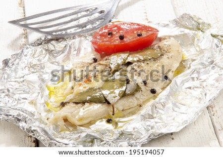 baked pangasius with pepper and tomato in tin foil