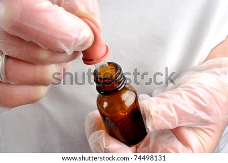 Health care staff with disposable gloves and pipette
