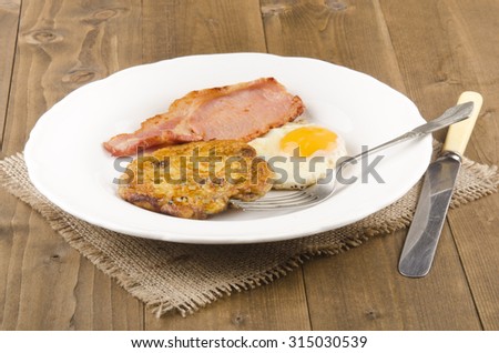 breakfast with pancake, bacon and fried egg on a plate