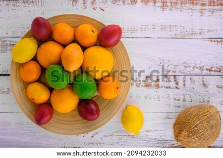 Citrus fruits on wooden vintage desk. Assorted citrus fruits and tamarillo. Coco on vintage table and other fruits. Copy space for your text. Sweet assorti for fresh brekker. Tamarillo assorti Photo stock © 