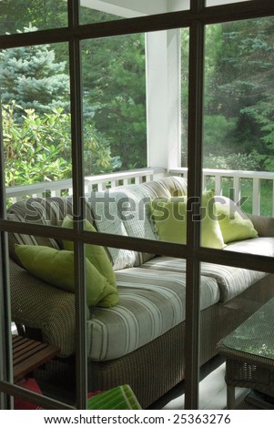 Screened in furnished porch viewed through door leading into house