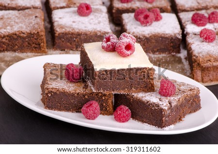chocolate brownie cake in the glaze of white chocolate with raspberries