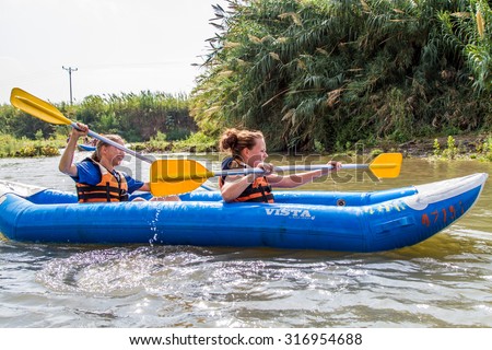 JORDAN RIVER, ISRAEL - OCTOBER 10: Two girls kayaking down the river at the Jordan River in northern Israel on October 10, 2014
