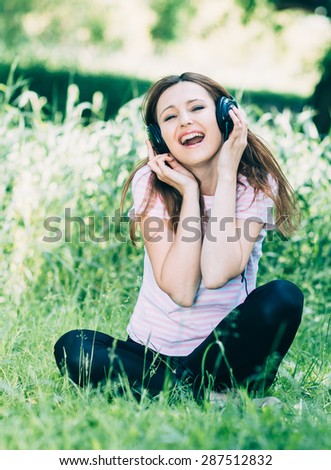 Woman in headphones. Emotional young woman in headphones