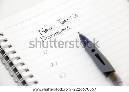 Writing new year’s resolutions, list on white notepad with ballpoint pen. Setting goals for the new year. Foto d'archivio © 