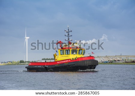 Amsterdam, Noord-Holland/Netherlands - June 09-06-2015 - PA4 (Port of Amsterdam 4)  is sailing at the Noordzeekanaal and observing in port. Smoke from a funnel at the background. Nice blue cloudy sky.