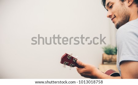 Similar – Image, Stock Photo Cheerful man playing ukulele guitar