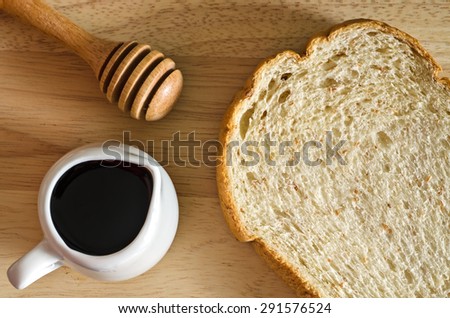 Still Life Dark Light Style of Slice Whole Wheat Bread Recipe and Honey Cup in Wooden Plate on Old Wood Table - Texture Background